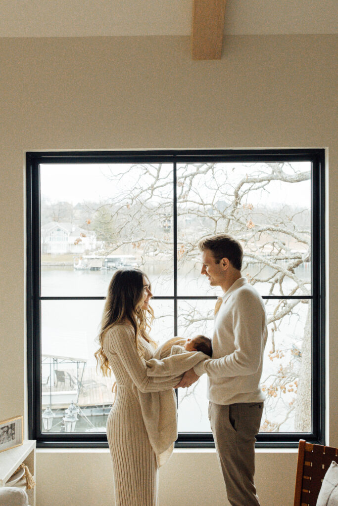 backlit family photo holding newborn